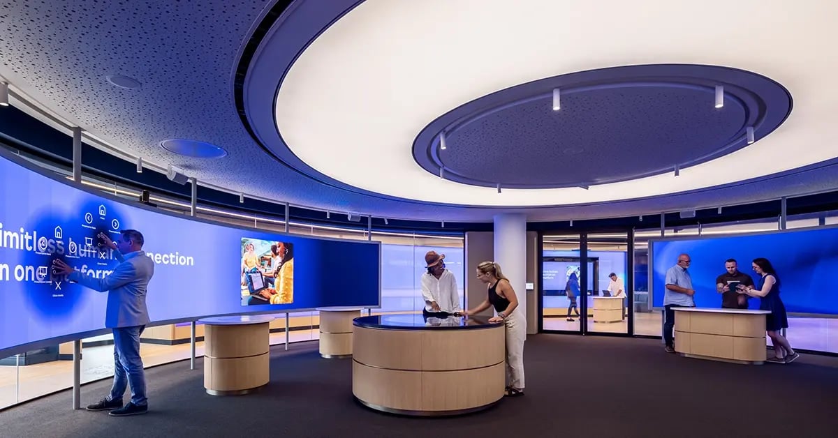 Visitors to the Zoom Experience Center in London interacting with touchscreens and touchtables. 