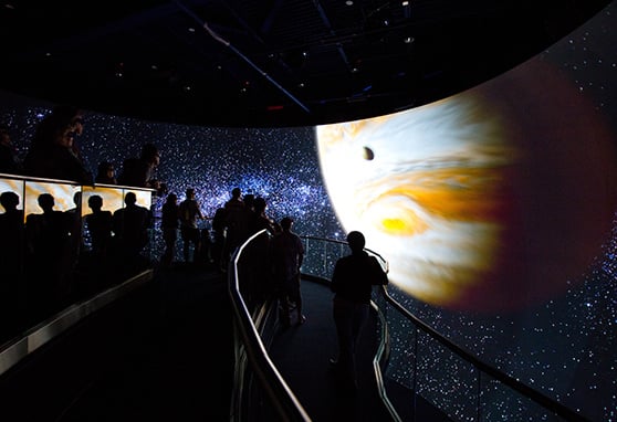 Visitors view images of a space capsule on a large video wall at the Kennedy Space Center in Florida.