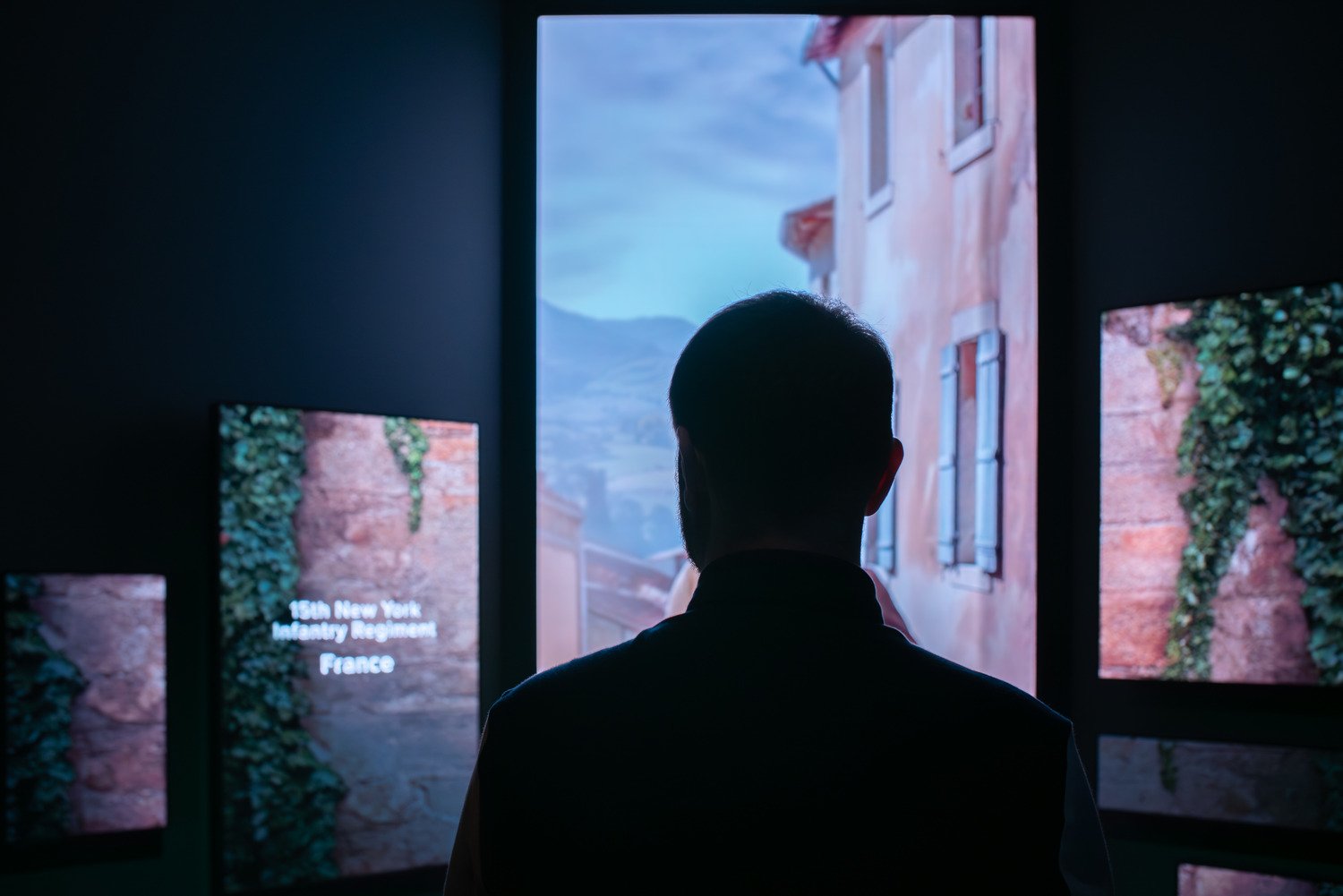 A man standing in front of four LED walls. 