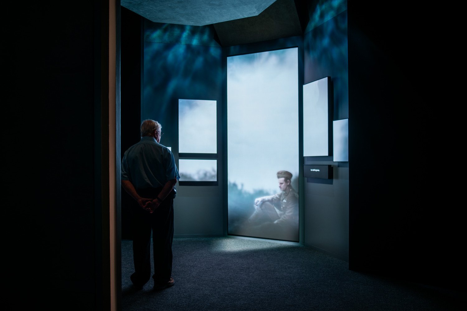 A man standing in front of a LED wall looking at the character