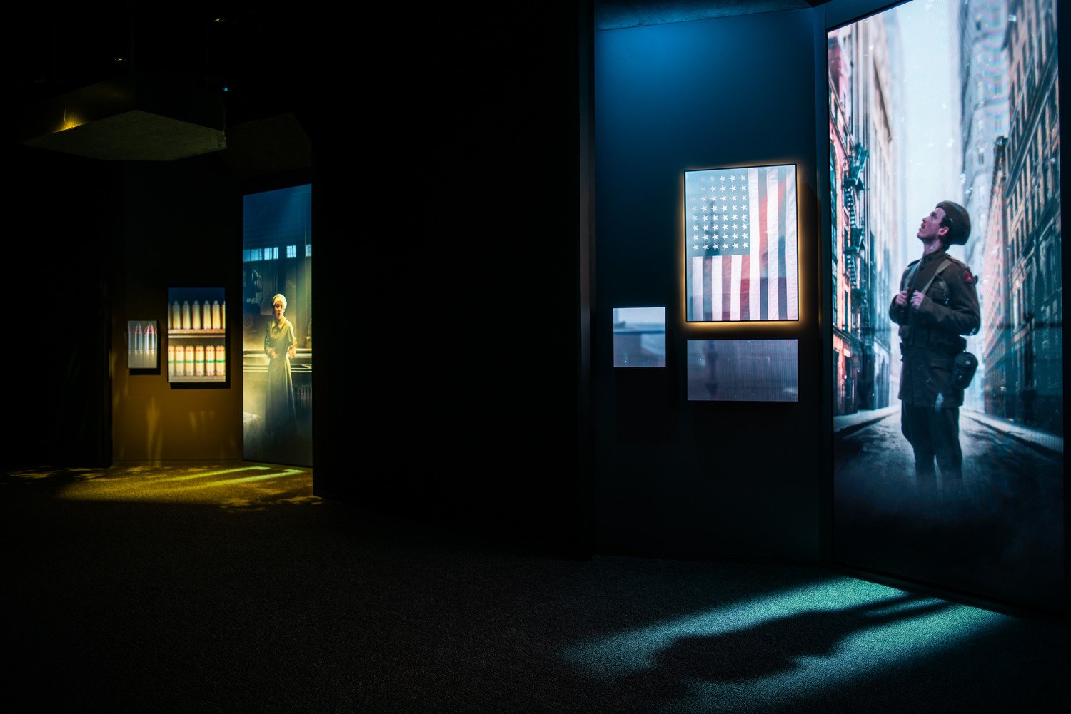 Two alcoves in the Encounters exhibit with characters on the screen. 