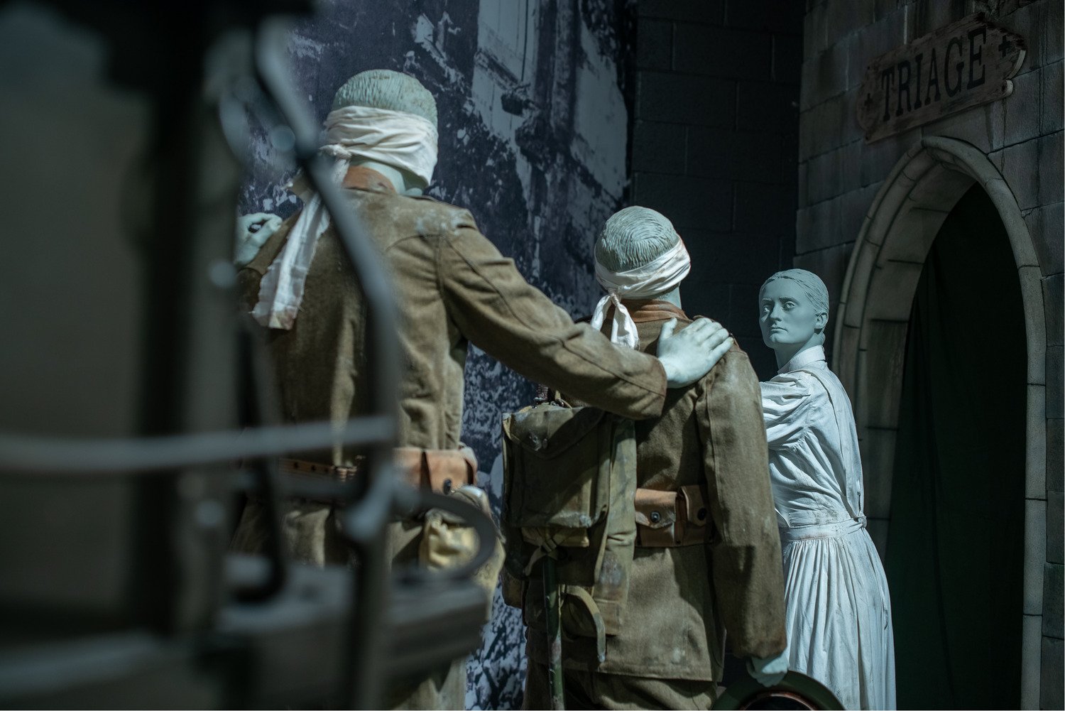 An exhibit with a woman and two injured soldiers. 