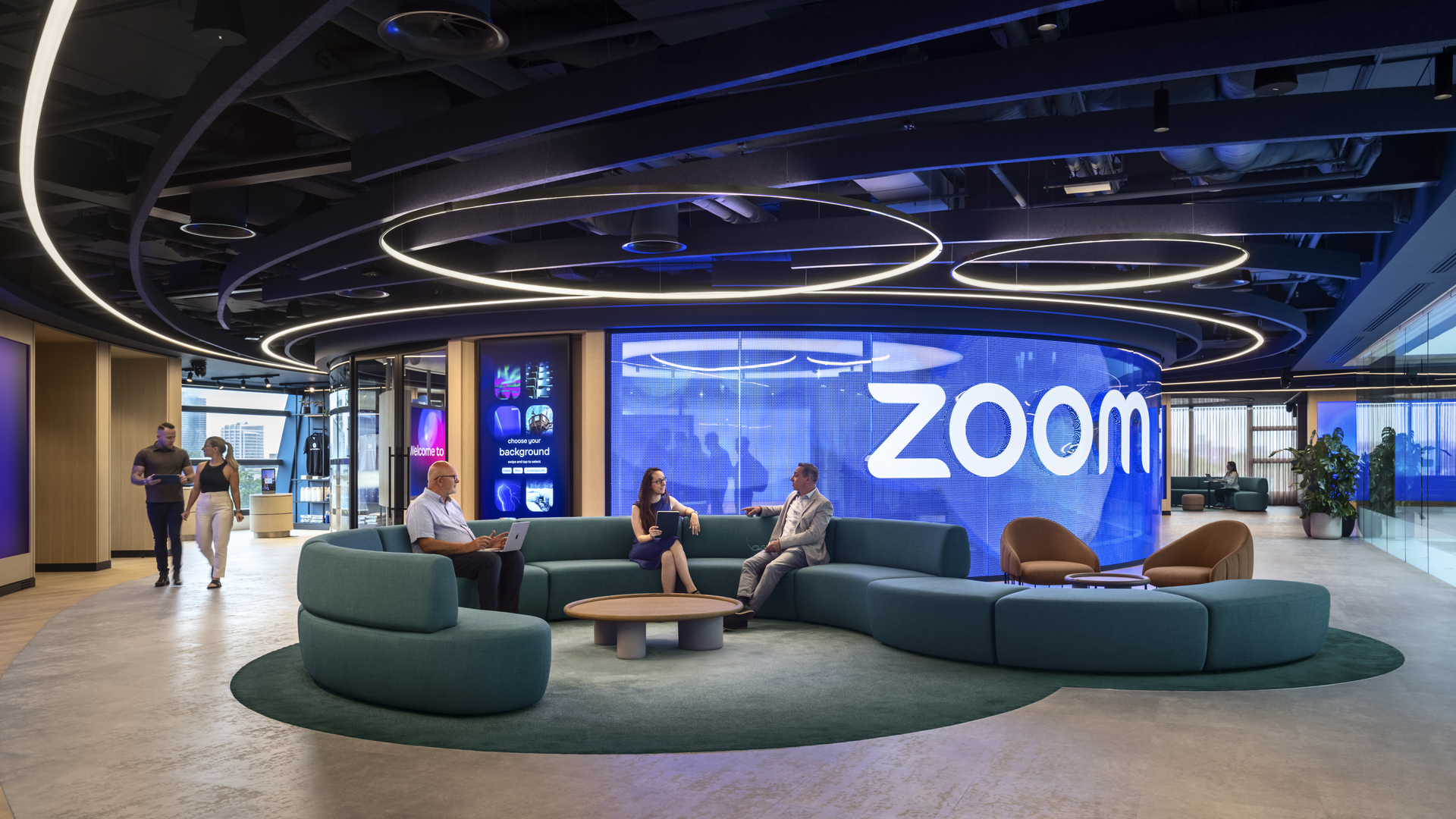 People sittign on the couch talking to each other in front of Zoom signage