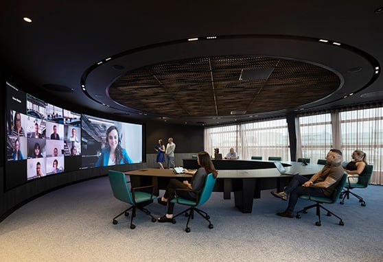 Group of employees sitting in the boardroom at the Zoom London Experience Center.