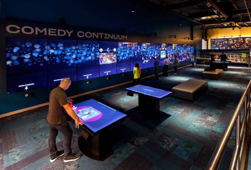 Guests to the National Comedy Center interacting with touchscreens and video walls.