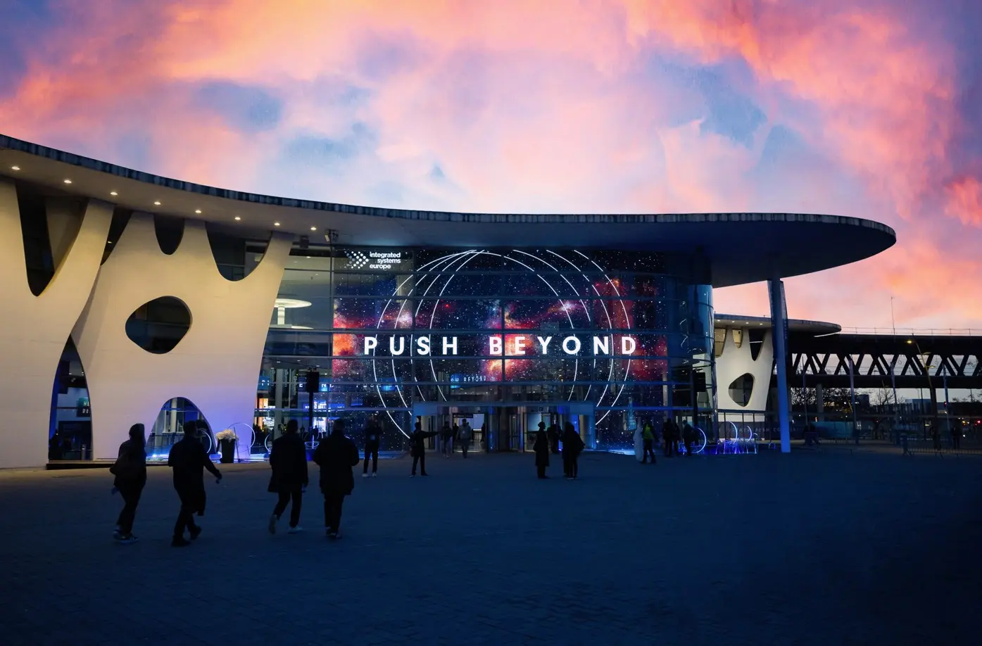 Guests enter the ISE 2026 show floor beneath a large “Push Beyond” banner suspended above the main entrance.